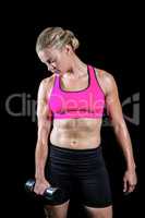 Muscular woman lifting heavy dumbbell