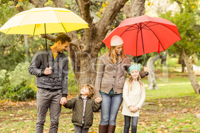 Smiling young family under umbrella