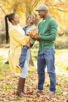 Portrait of a young smiling family holding leaves