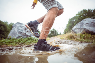 Man splashing in muddy puddles