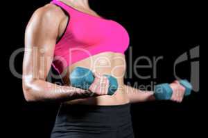 Muscular woman lifting heavy dumbbells