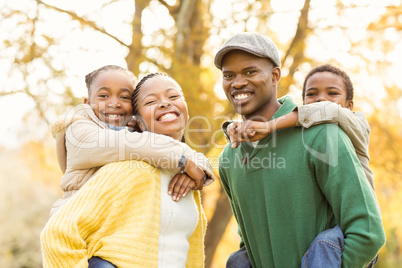 Portrait of a young smiling family in piggyback