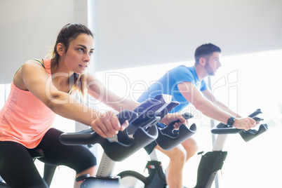 Man and woman using cycling exercise bikes