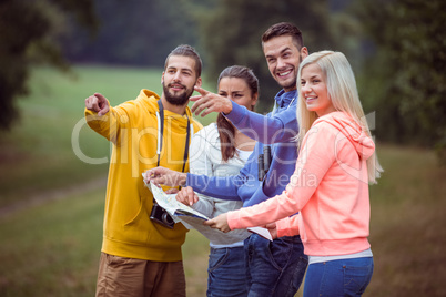 Happy friends reading a map together