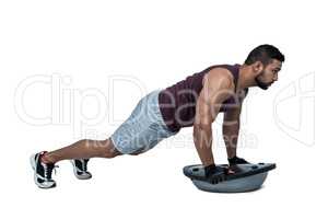 Muscular man doing bosu push ups