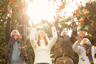 Happy family throwing leaves around