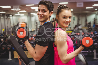 Fit couple lifting dumbbells together