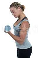 Muscular woman working out with dumbbells