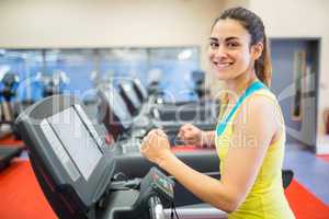 Smiling woman running on a treadmill