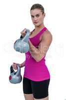 Muscular woman exercising with kettlebells