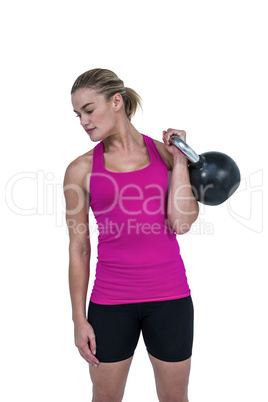 Muscular woman exercising with kettlebell