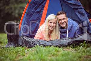 Happy couple lying in their tent