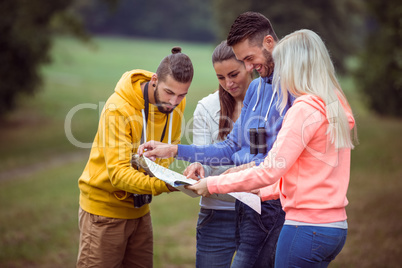 Happy friends reading a map together