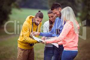 Happy friends reading a map together