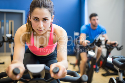 Focused couple using exercise bikes