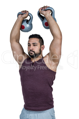 Muscular serious man lifting kettlebells