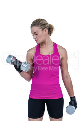 Muscular woman exercising with dumbbells