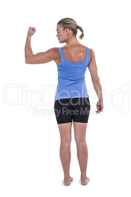 Rear view of muscular woman flexing muscles