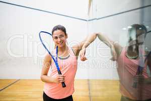 Smiling woman holding a squash racket