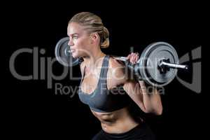 Muscular woman lifting heavy barbell