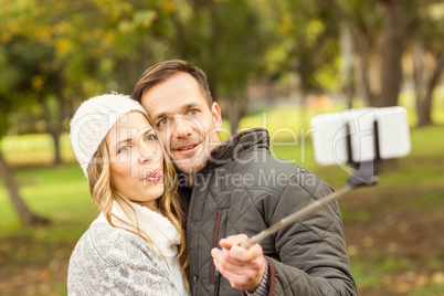 Smiling young couple taking selfies