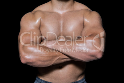 Mid section of a bodybuilder man with arms crossed