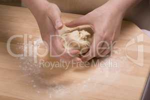woman hands kneading  dough on wooden table