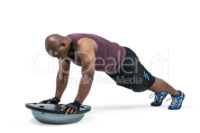 Fit man exercising with bosu ball