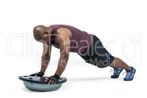 Fit man exercising with bosu ball