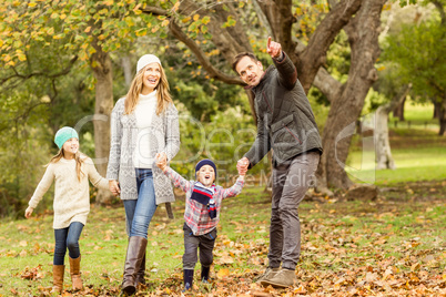 Young family running in leaves