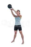 Serious muscular woman lifting kettlebell