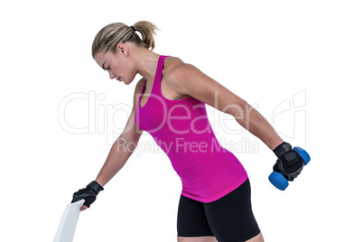 Muscular woman exercising with dumbbells