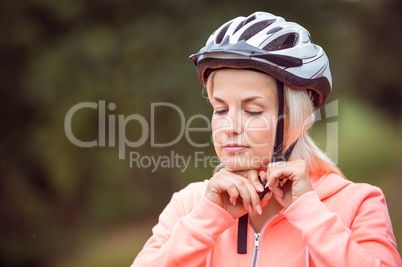 Woman fastening her bike helmet