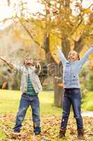 Portrait of young children throwing leaves around