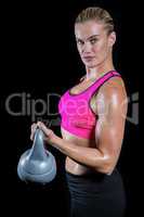 Muscular woman lifting heavy kettlebell