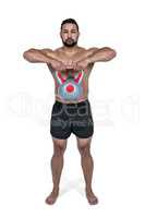 Muscular man lifting heavy kettlebell
