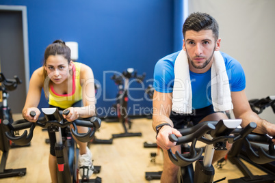 Focused couple using exercise bikes