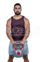 Muscular serious man holding a kettlebell