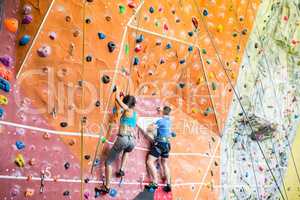 Fit couple rock climbing indoors
