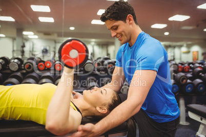 Woman lifting dumbbells with her trainer