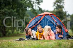 Happy friends lying in their tent