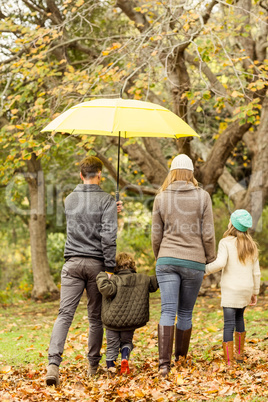 Rear view of young family under umbrella