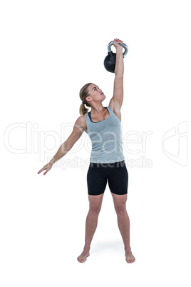 Serious muscular woman lifting kettlebell