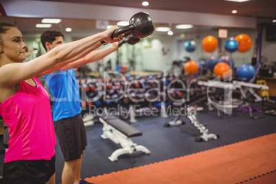 Fit couple working out in weights room