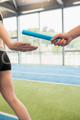 Man passing the baton to partner on track