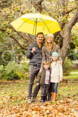 Smiling young family under umbrella