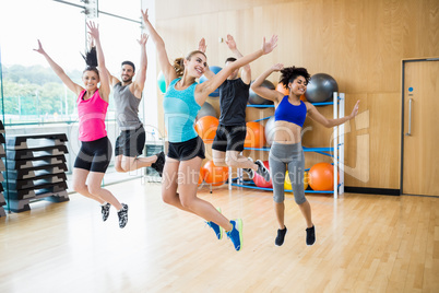 Fitness class jumping up in studio
