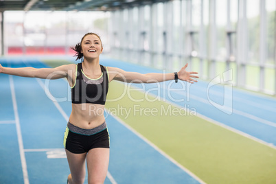 Fit woman running on track cheering