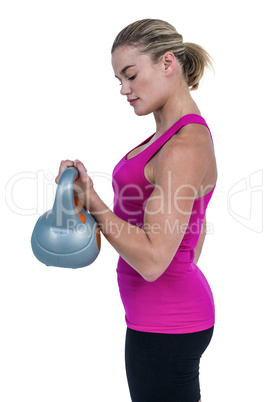 Muscular woman exercising with kettlebell