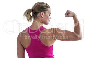 Rear view of muscular woman flexing muscles